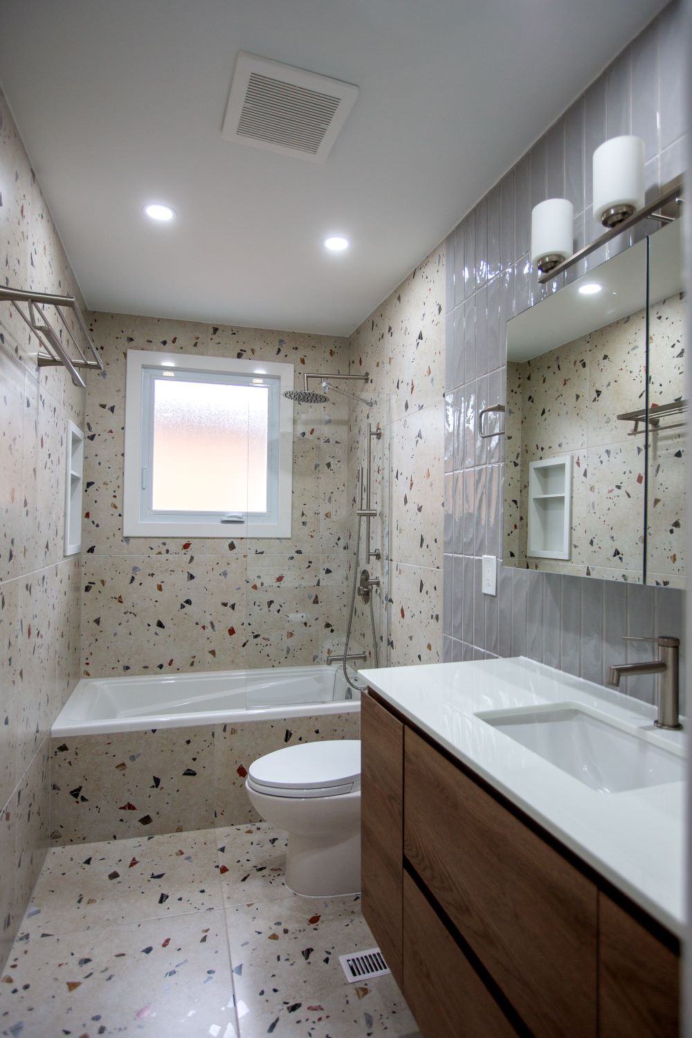 A “floating” vanity unit with a wood finish (resembling oak) features two spacious drawers with flat fronts. The composition is completed by a white countertop with an integrated rectangular sink Barrie