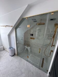 Bathtub to steam shower conversion. Glass steam shower enclosure with matte brass fixtures