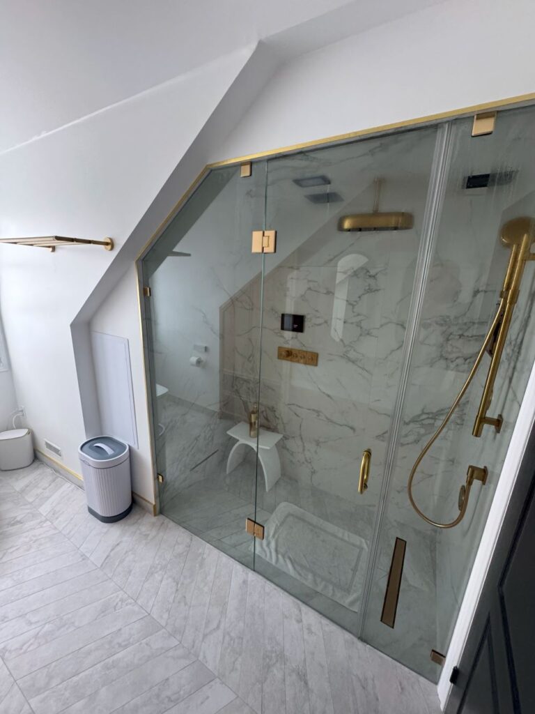 Glass steam shower enclosure with matte brass fixtures
