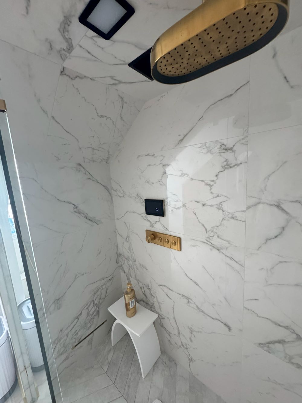 Interior of steam shower with marble look tile and rainfall showerhead Barrie