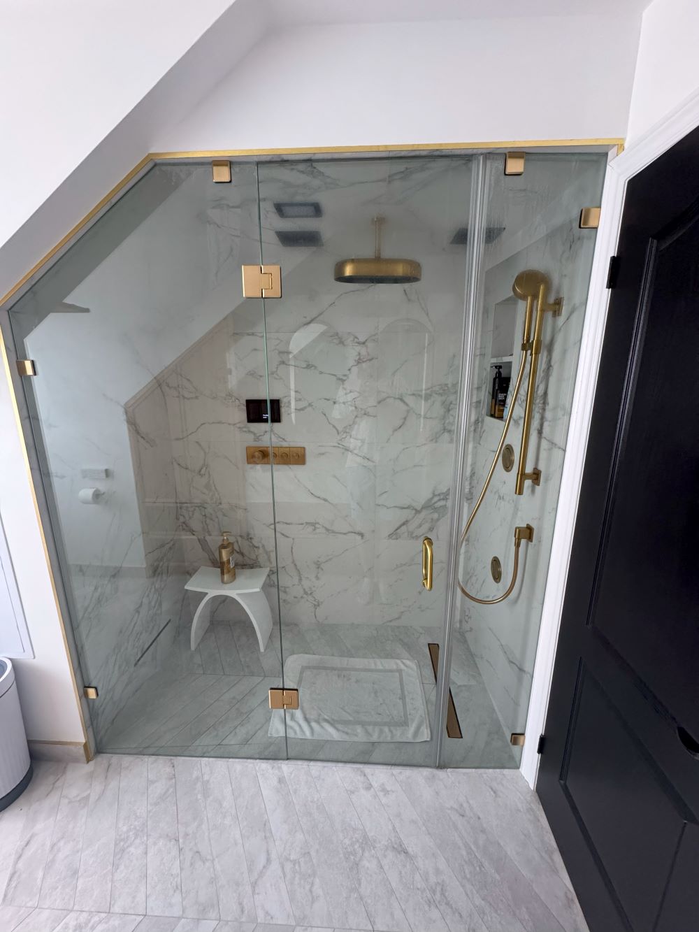 Bathtub to shower conversion. Steam shower floor with herringbone tiles and brass drain Barrie
