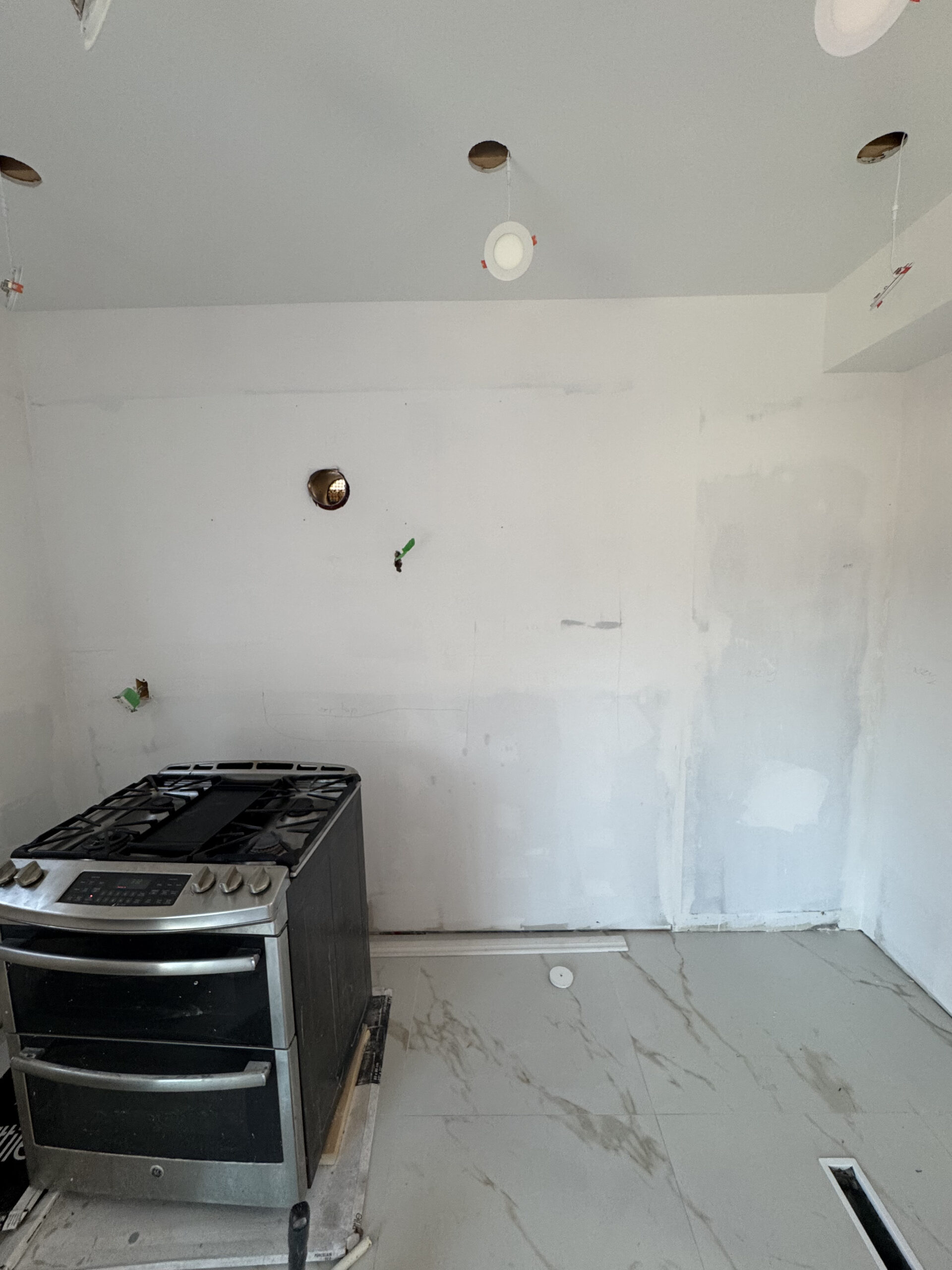 A clean slate after drywall and priming in the renovated kitchen with new porcelain flooring and po Pickering