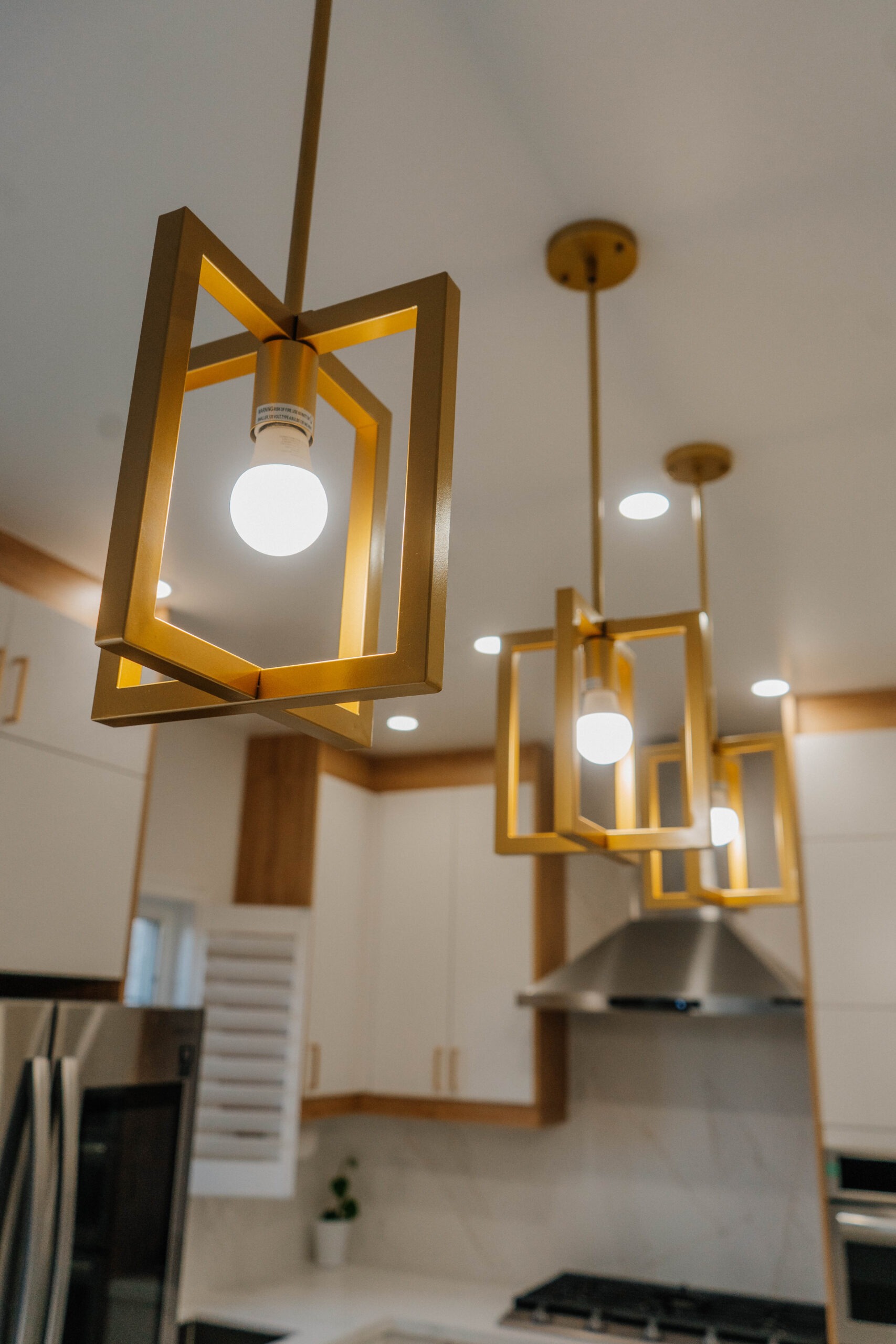 Artistic close up showcasing the design of the intersecting square gold pendant lights in the Thornhill Deluxe Style kitchen