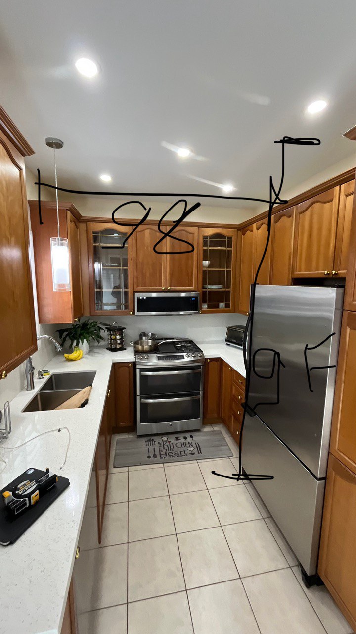 Before photo of a cramped U shaped kitchen featuring warm cherry wood cabinets, white countertops, stainless steel appliances Pickering