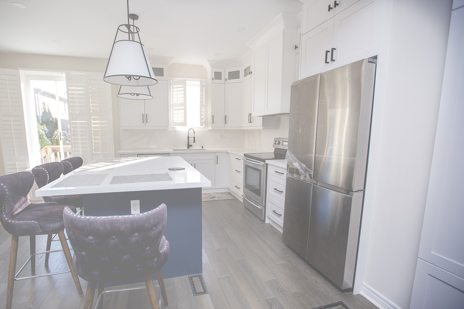 Bright modern kitchen renovation in Richmond Hill featuring white Shaker cabinets, a large blue island, and light wood look tile flooring.