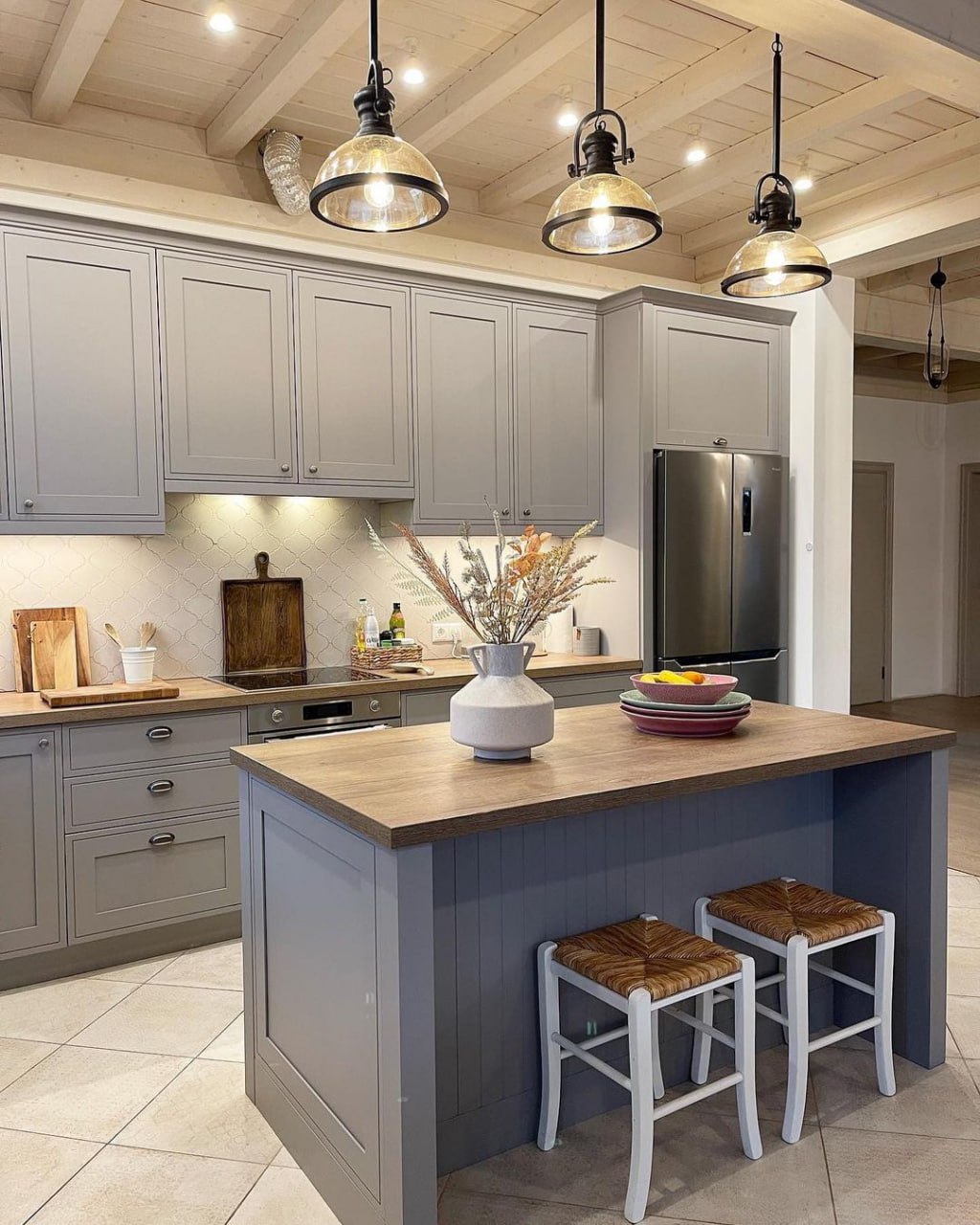 Central view of a gray transitional kitchen with a butcher block style island and industrial glass dome pendant lighting Pickering