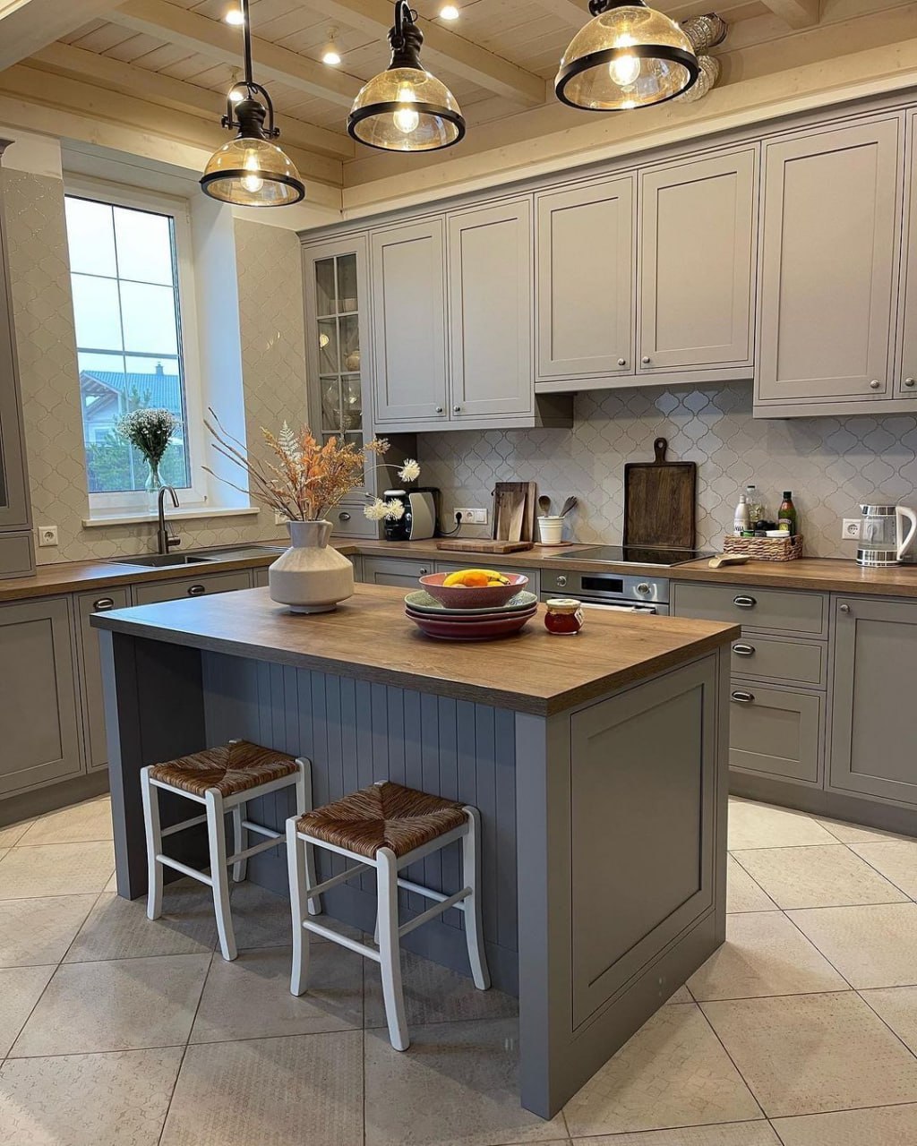 Charming farmhouse style kitchen with light gray Shaker cabinets, rustic wood island top, and glass pendant lighting fixtures Pickering