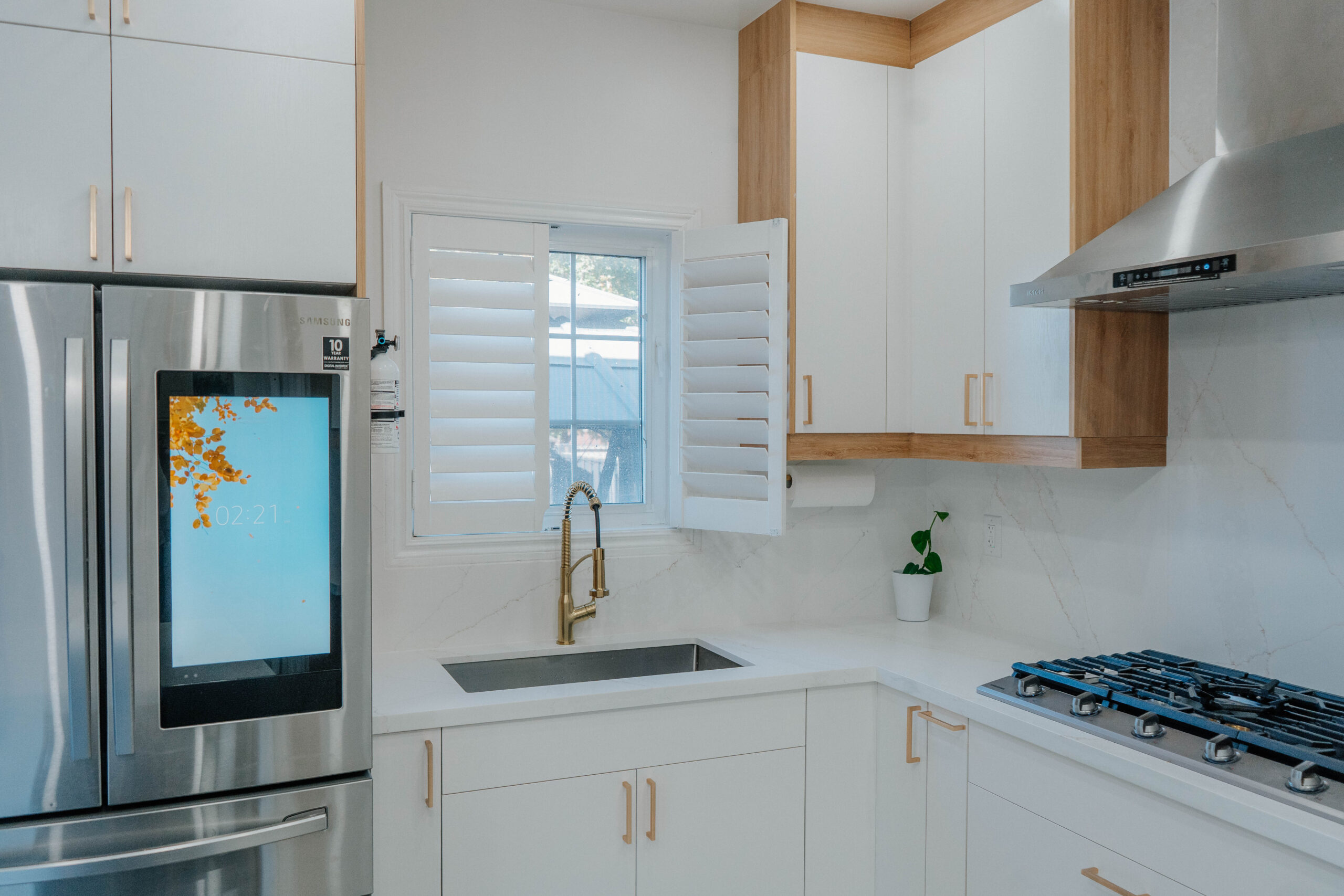 Close up of the sink area in the renovated Thornhill kitchen, featuring a smart fridge, gold faucet, and two tone Matte White and Rustic Oak cabinets Pickering