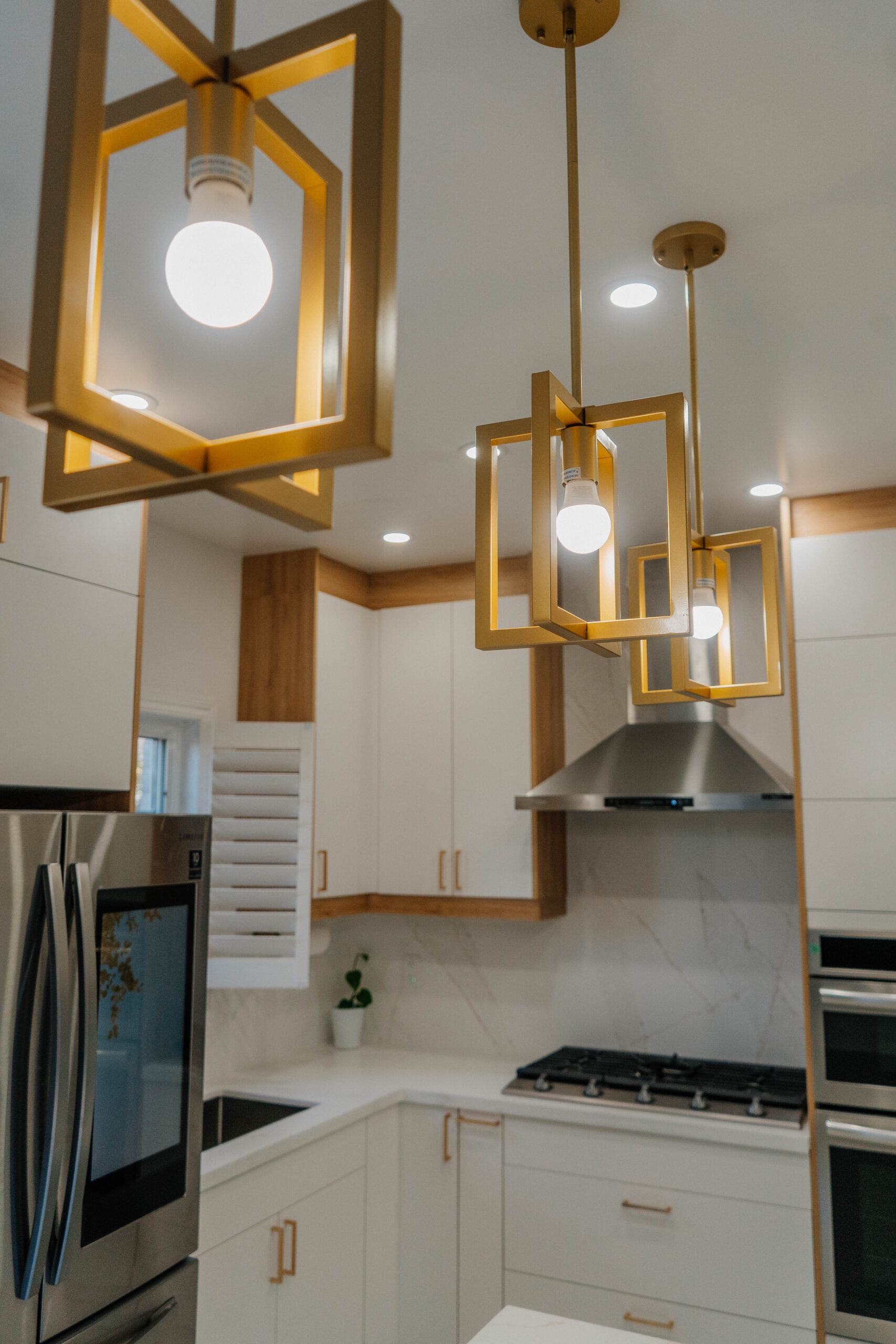 Close up of the three modern geometric gold pendant lights that hang above the kitchen island, adding a touch of luxury Pickering