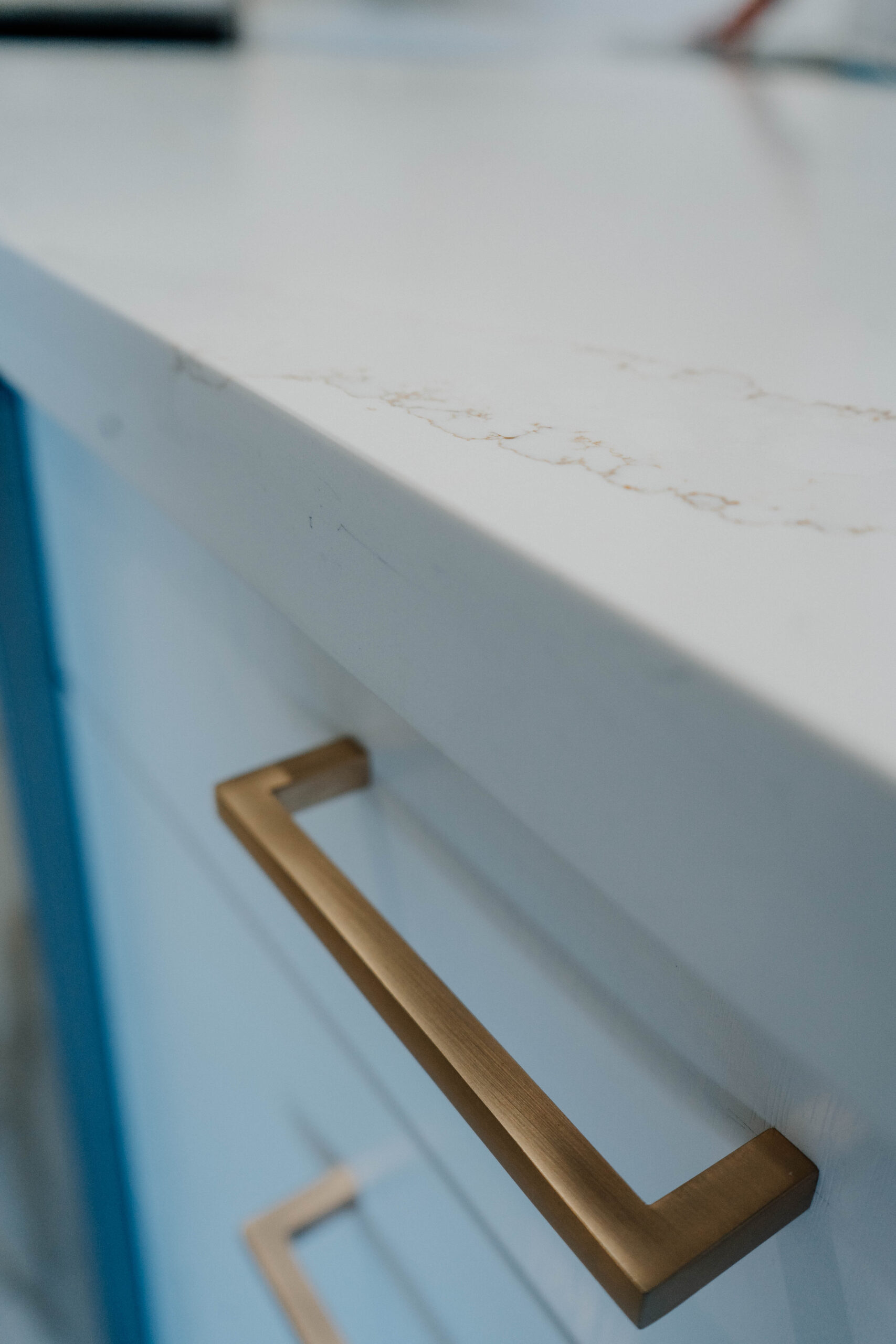 Detail of a brushed gold square bar pull, showcasing the modern hardware chosen for the Deluxe Style kitchen cabinets Pickering