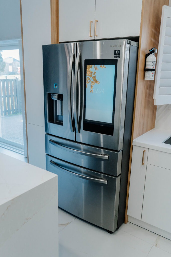 Detail of the Samsung smart refrigerator with touchscreen, perfectly integrated within the two tone kitchen cabinetry in this Thornhill home