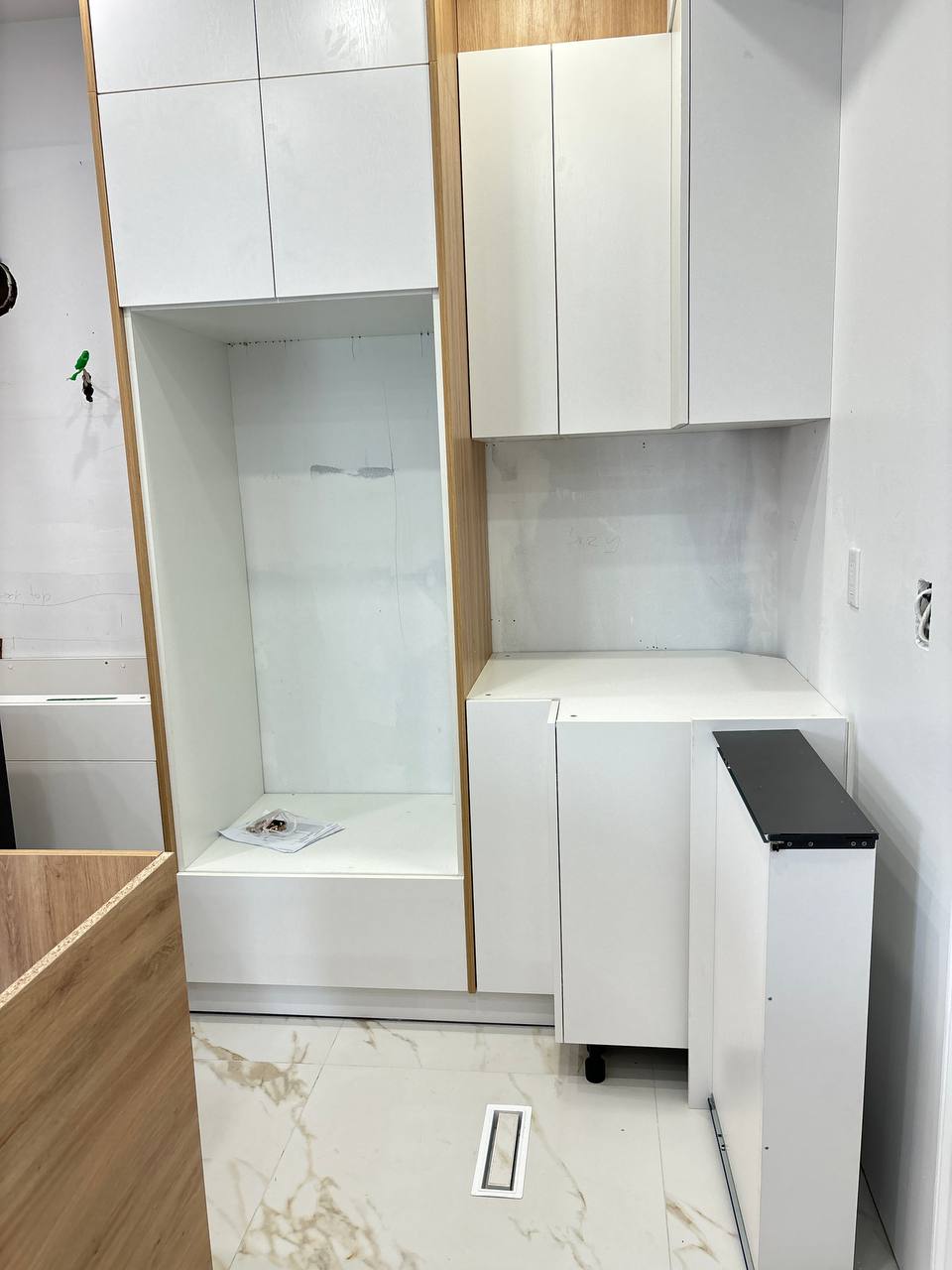 Detail view of the installed kitchen cabinets, showing the designated space for the double wall oven and a pull out cabinet, prior to countertop fitting Pickering