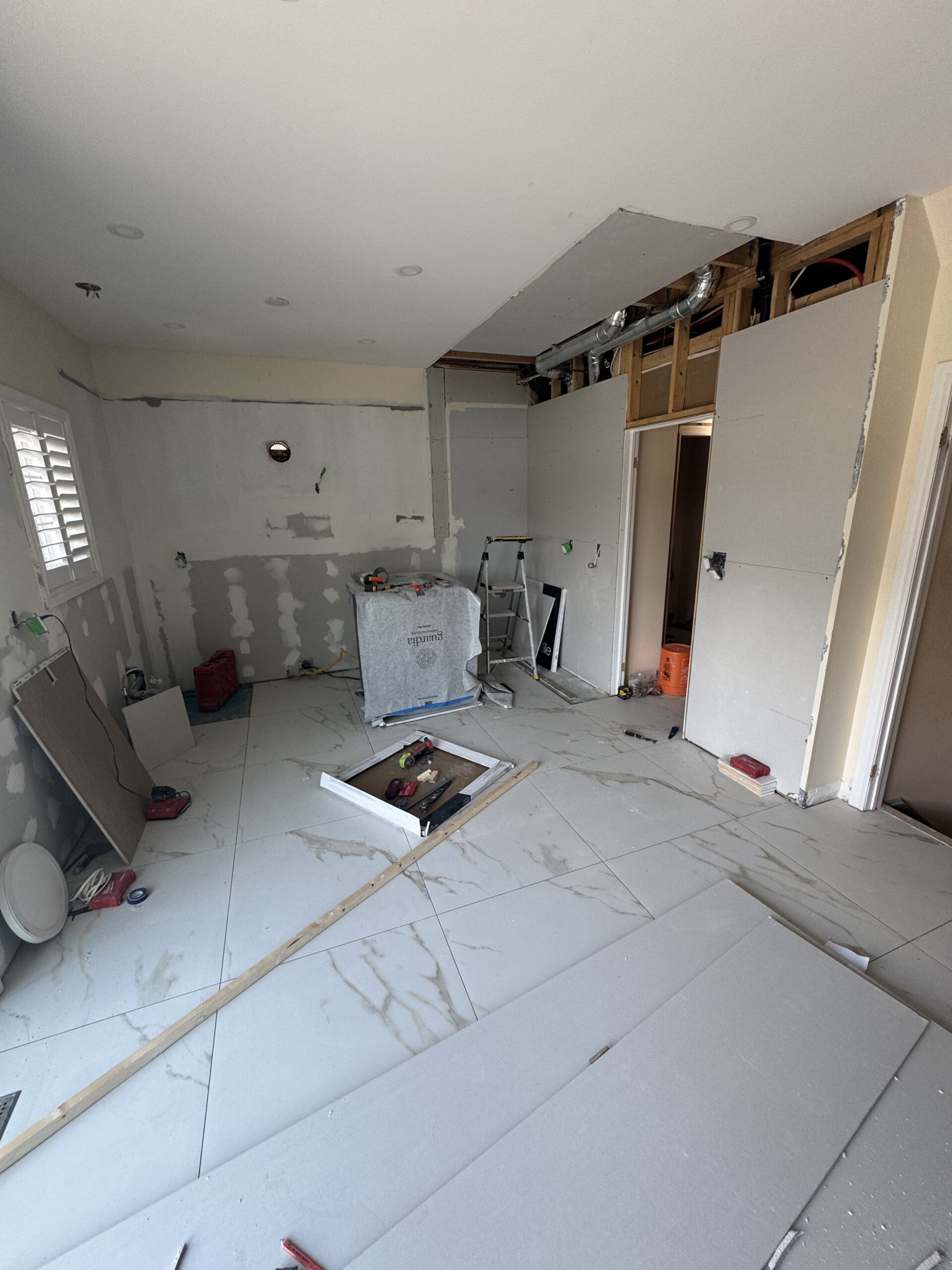 Drywall installation phase of the kitchen renovation showing the new walls taking shape over the ne Pickering