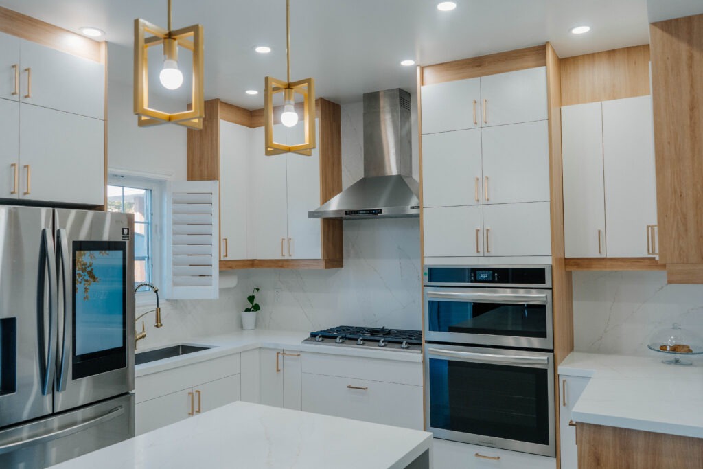 Full view of the renovated Thornhill kitchen wall, showcasing the two tone cabinetry, integrated appliances, and the quartz island in the foreground