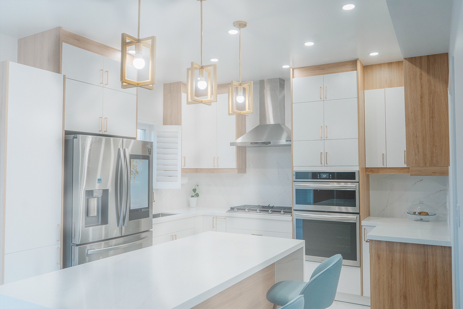 Kitchen renovation Etobicoke, showing the harmonious layout of the two tone cabinets, quartz island, and modern gold lighting fixtures копия
