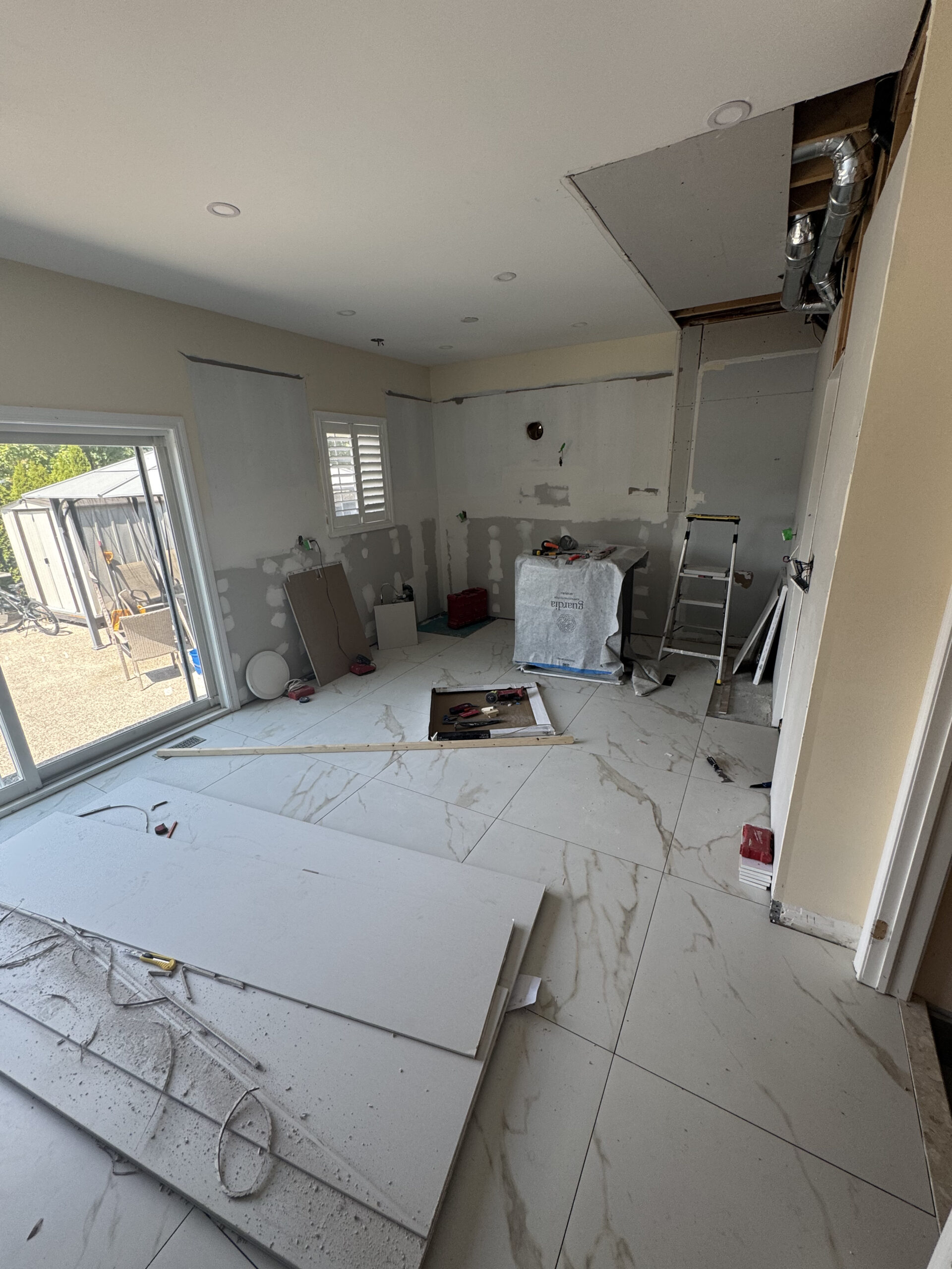 Progress shot of the Thornhill kitchen remodel during the drywall phase with the new large format p Pickering