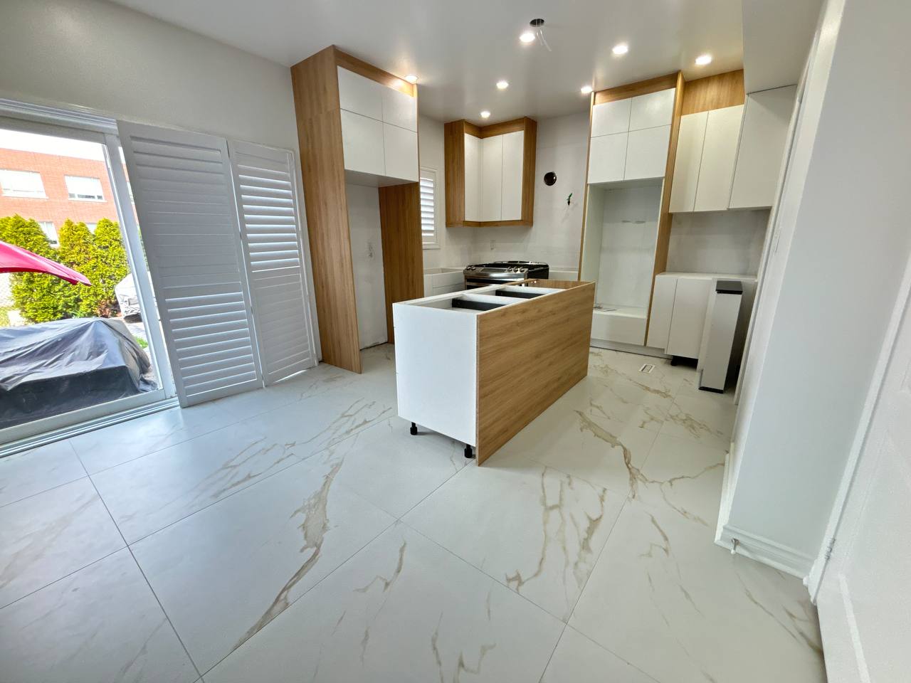 Progress shot of the kitchen renovation, with two tone Rustic Oak and Matte White cabinets installed, awaiting countertops and backsplash Pickering