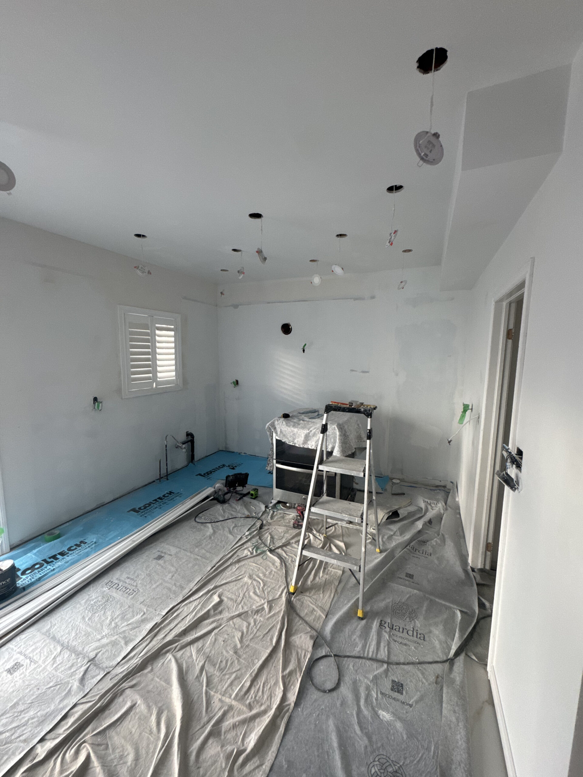 The kitchen after new drywall installation and priming with wiring ready for the new pot lights and Pickering