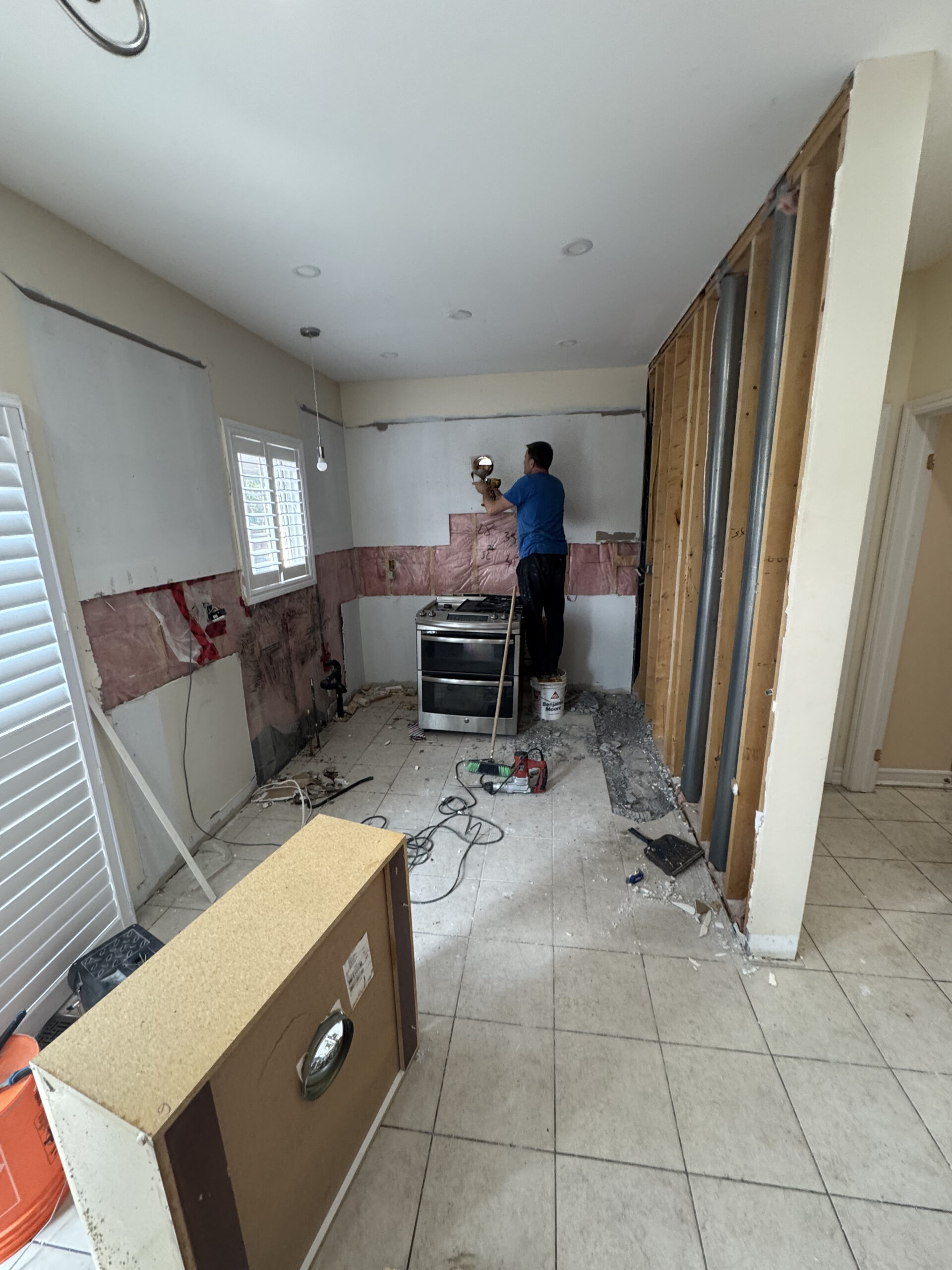 The kitchen demolition phase in progress with the wall opened up to the studs to prepare for the 50 Pickering