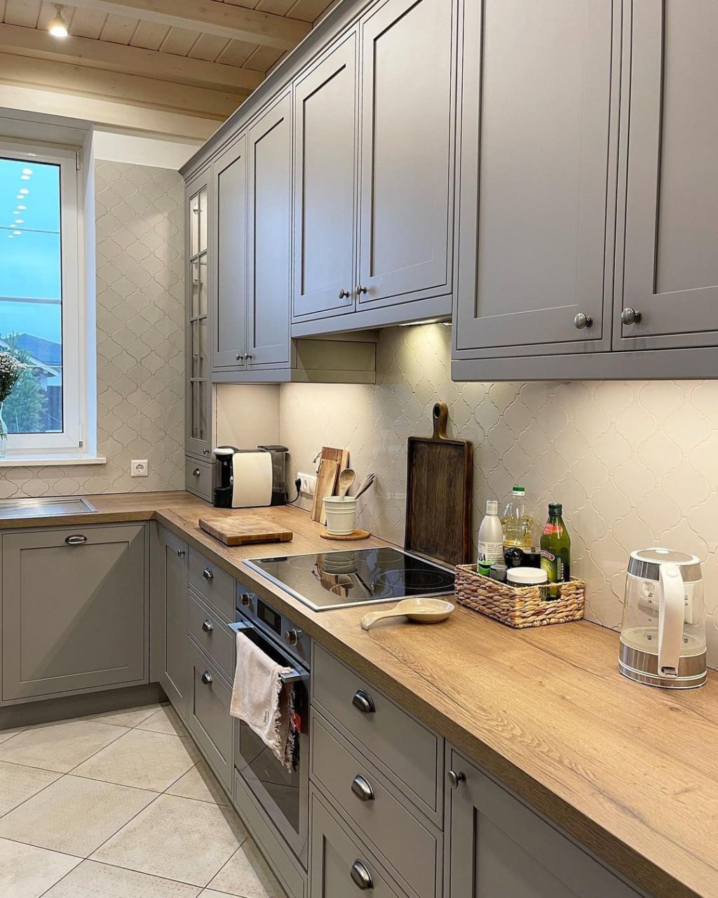 U shaped grey kitchen featuring wood countertops, black induction cooktop, and curved tile backsplash Pickering