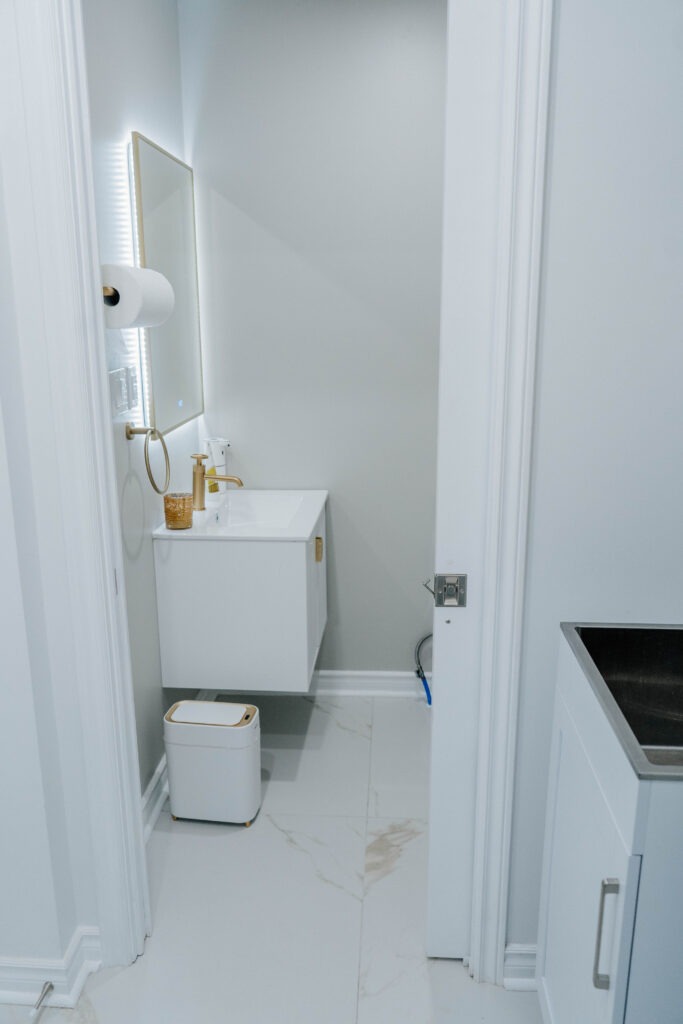 View from the laundry room into the newly constructed powder room, showing how the two distinct spaces are connected