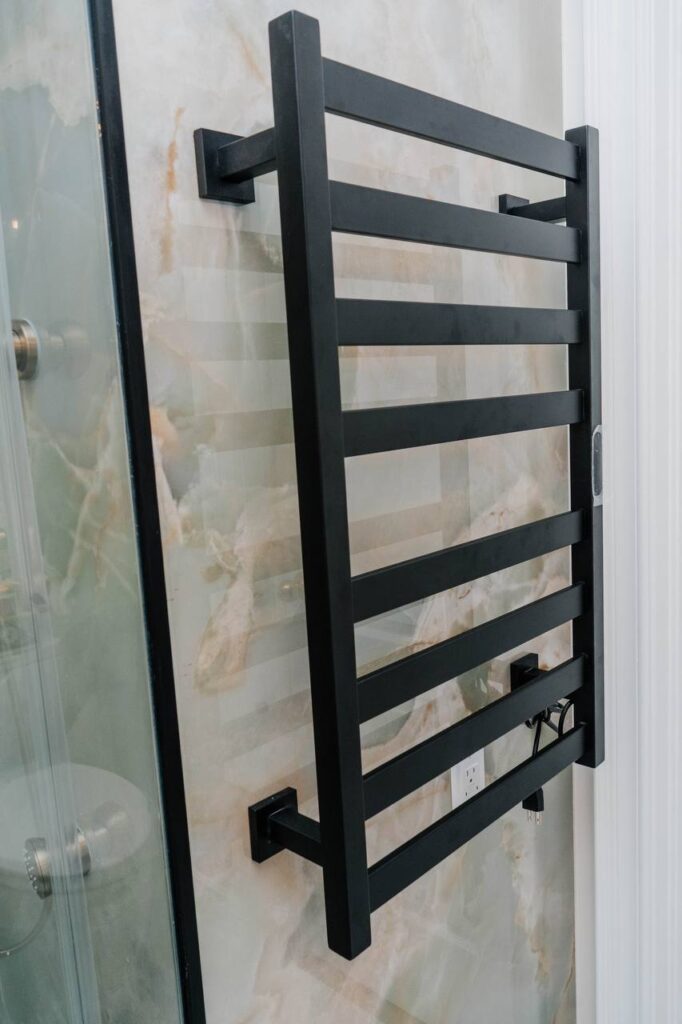 (Angle View) Modern bathroom featuring electric towel rail and large format stone slabs