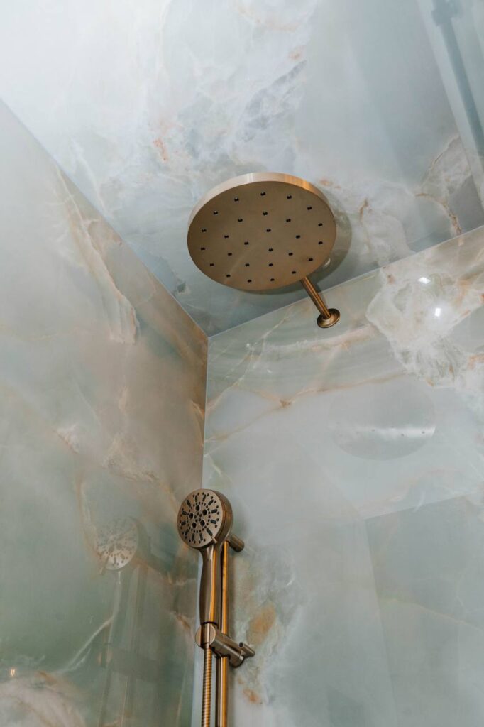 Ceiling mounted Delta rain shower head in champagne bronze finish.