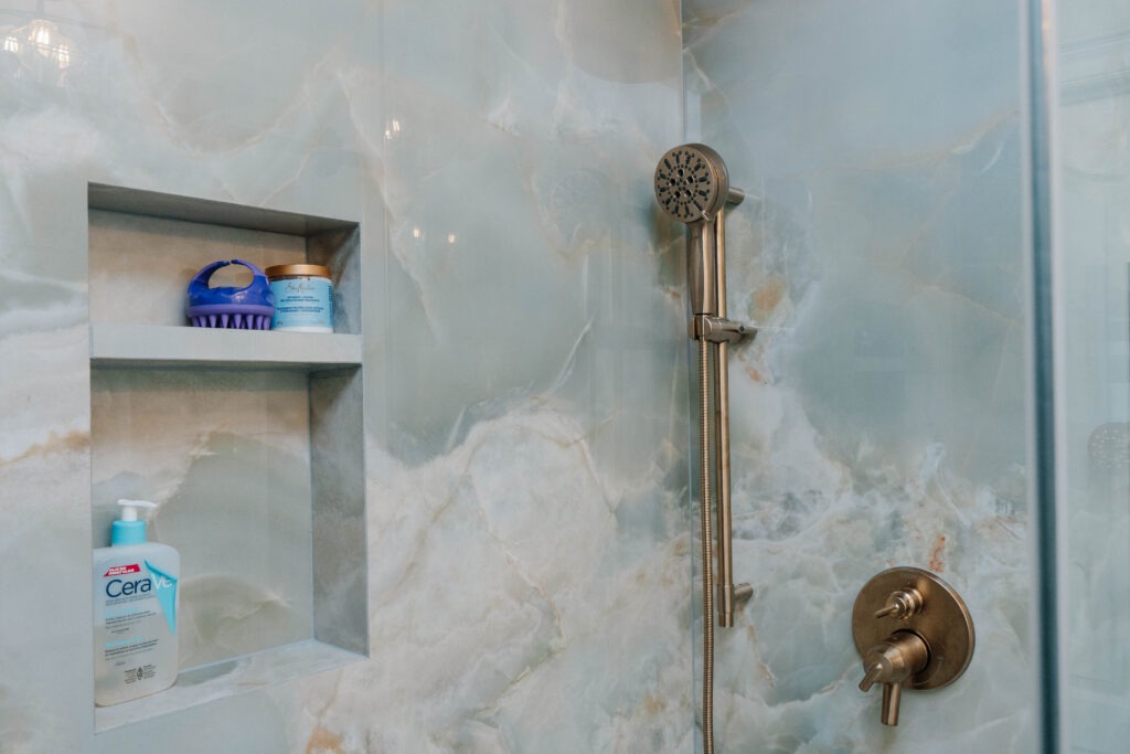 Custom tiled shower niche with 45 degree mitered edges and epoxy grout in onyx look porcelain