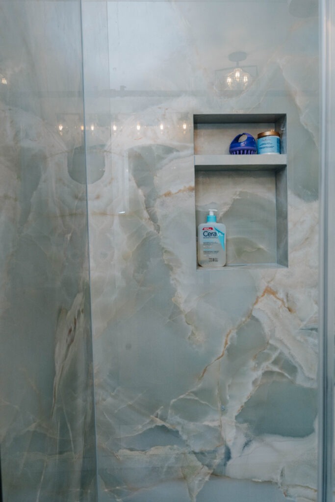 Shampoo niche clad in large format porcelain with seamless mitered joints.