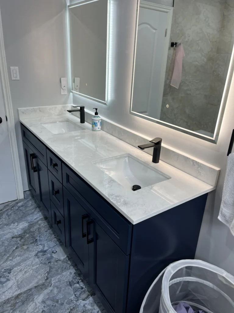 Navy blue floating vanity with white quartz countertop and matte black faucet in a modern bathroom
