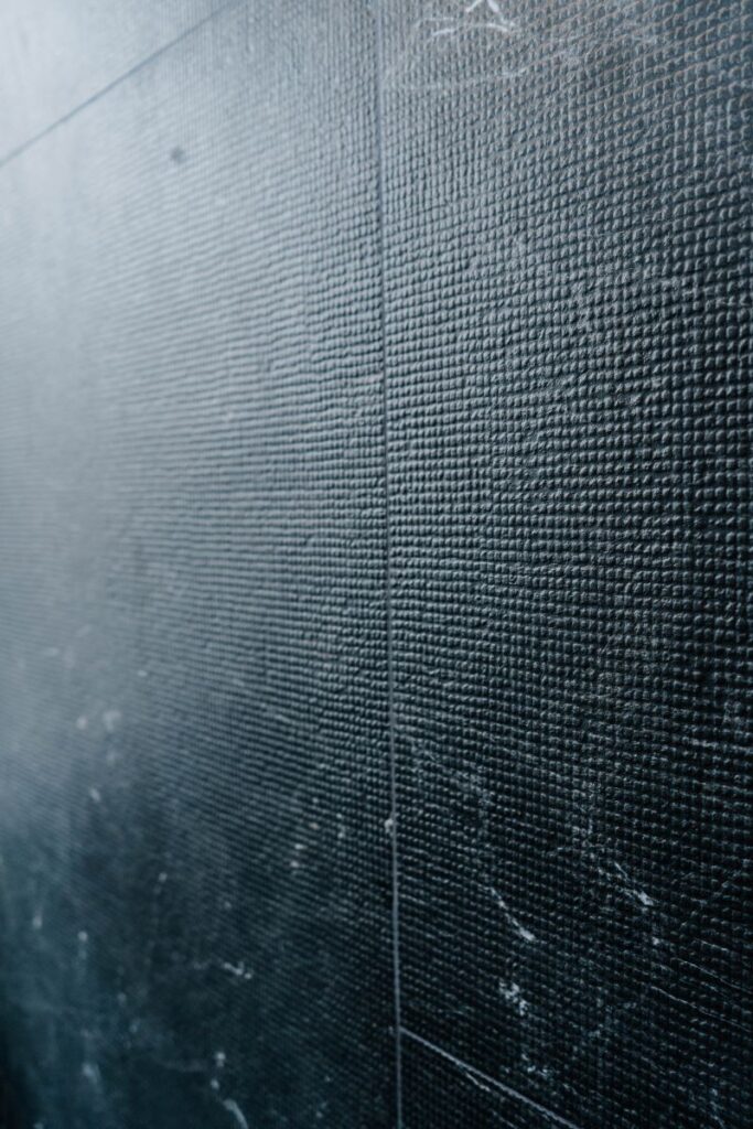 Close up texture of large format dark grey slate look porcelain wall tiles