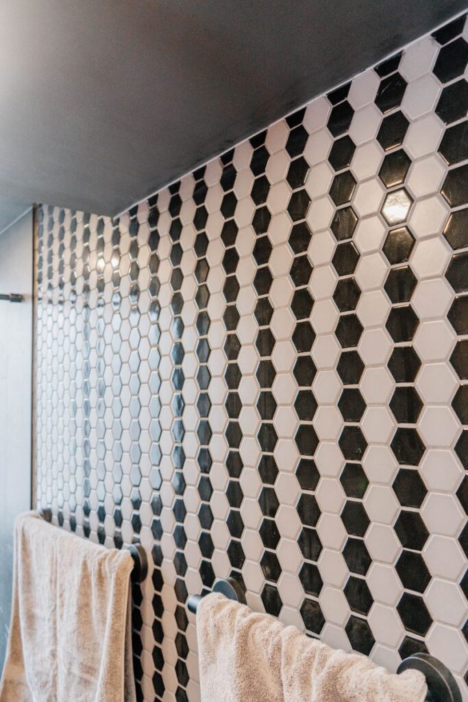 Detail texture of black and grey hexagon mosaic wall tiles in a modern Toronto condo bathroom