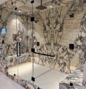 Large custom steam shower with full marble mosaic seating and dual shower heads
