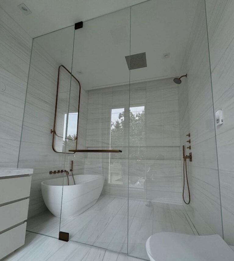 Luxury master bathroom renovation featuring custom glass steam shower enclosure freestanding tub
