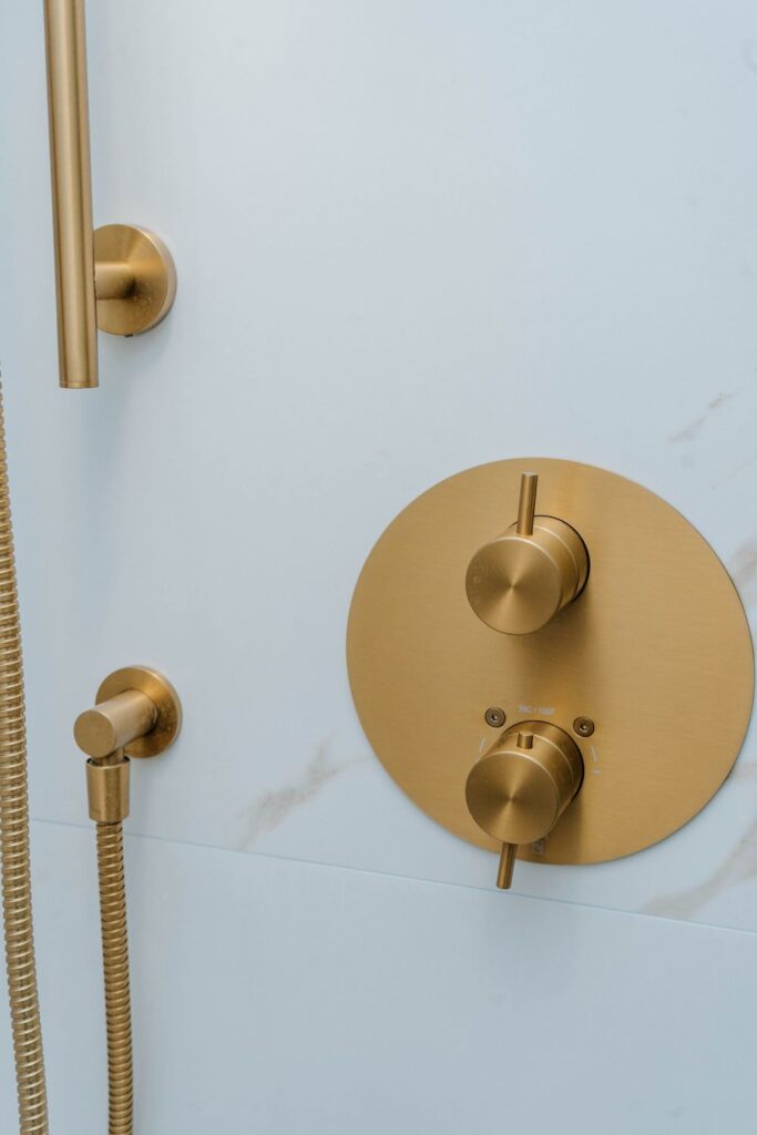 Detail of Moen brushed gold shower valve controls with temperature settings