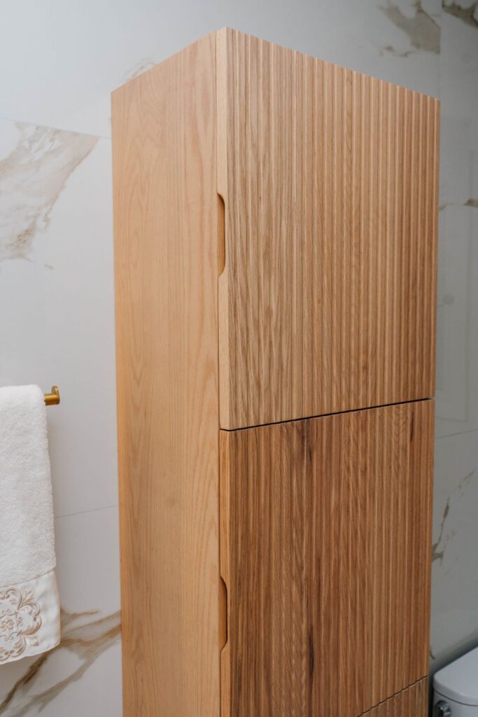 Detail of the wood grain texture on a custom fluted oak bathroom cabinet