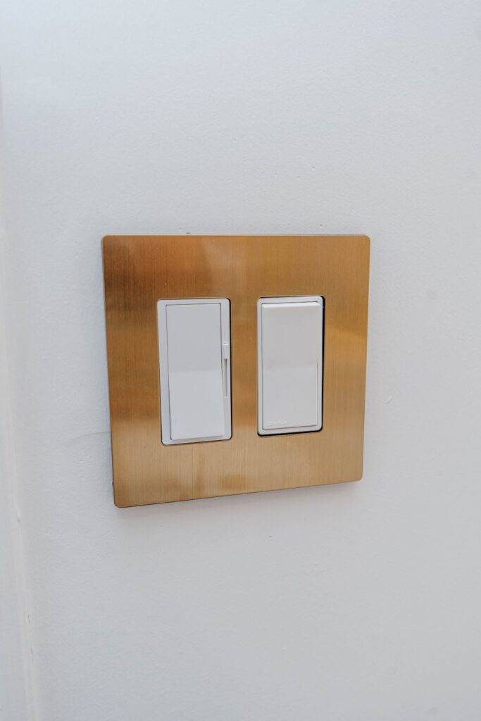 High end brushed gold Leviton light switches installed on a white wall