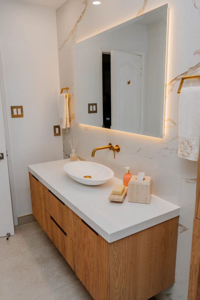 Modern floating bathroom vanity made of ribbed (fluted) light oak with a white quartz countertop