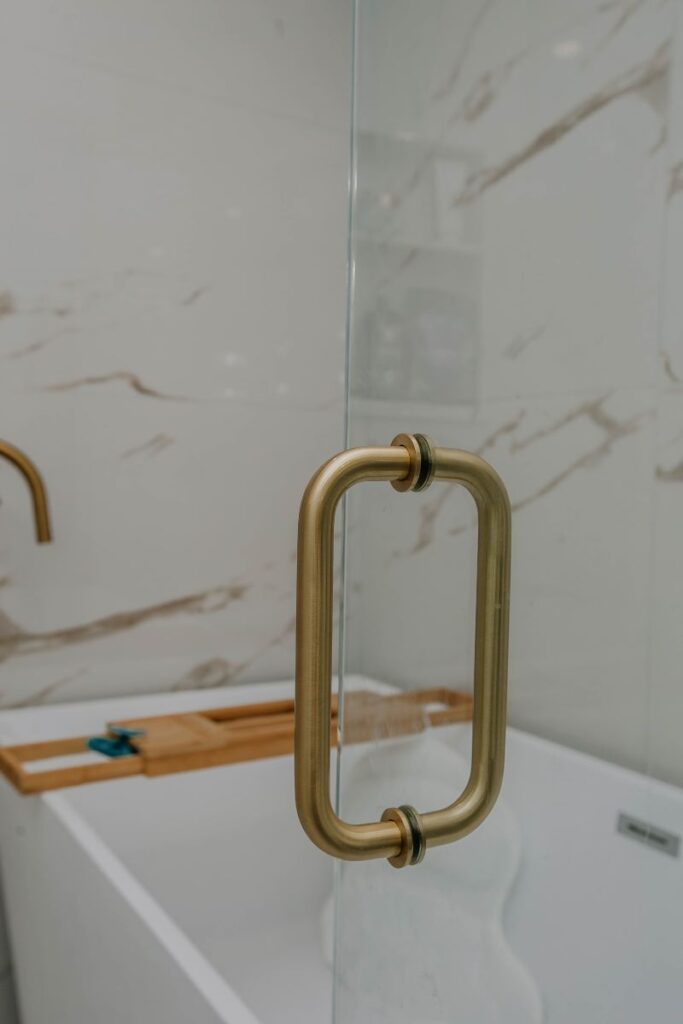 Brushed gold shower glass door handle detail in custom master bathroom