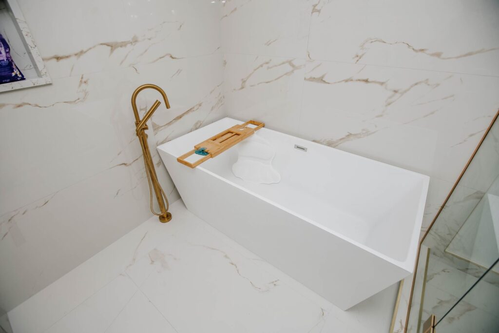 Freestanding tub and marble look porcelain tile in modern master ensuite