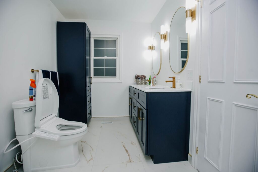 Full master bathroom layout with toilet, custom vanity and tall storage cabinet