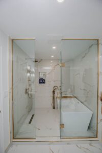 Luxury master bathroom renovation with glass shower enclosure and freestanding tub in Thornhill