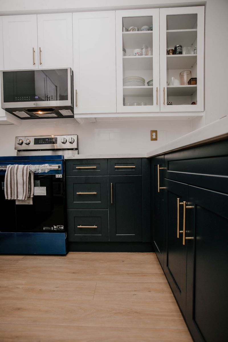 Completed two tone condo kitchen renovation with navy lower cabinets, white shaker uppers and glass front display cabinets