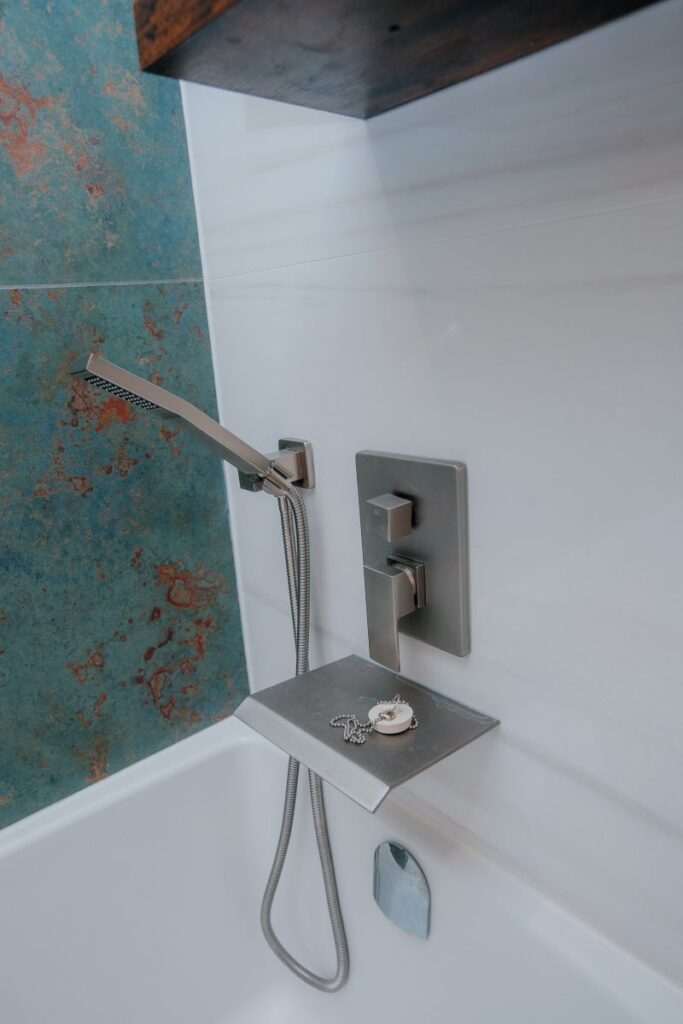 Modern tub filler and control set detail in custom master bathroom