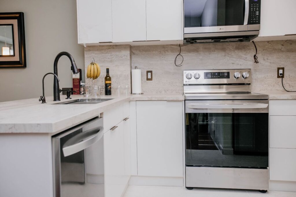 compact condo kitchen with white cabinetry and quartz surfaces