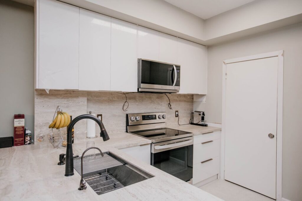 modern condo kitchen with peninsula and porcelain tile flooring