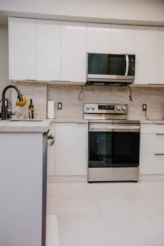 modern condo kitchen with stainless steel oven and quartz backsplash