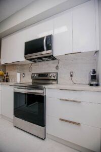 white kitchen cabinets with stainless steel range and microwave hood