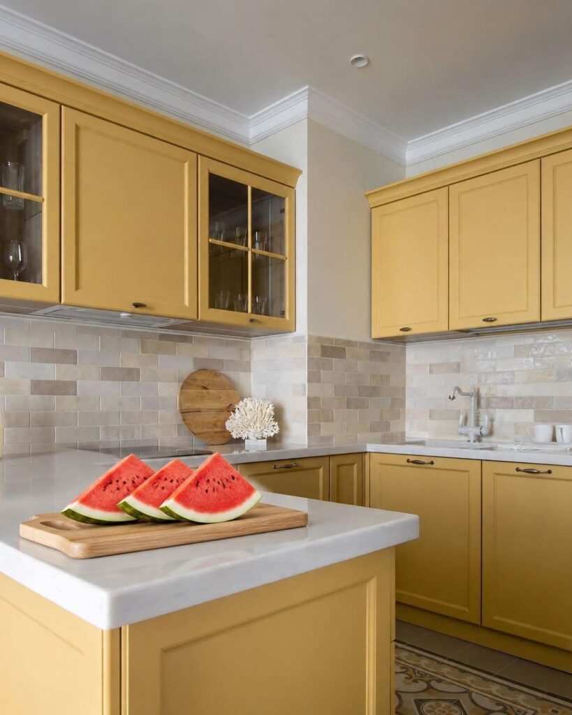 Bright yellow kitchen remodel with white countertop, tile backsplash, and sliced watermelon on a wooden cutting board