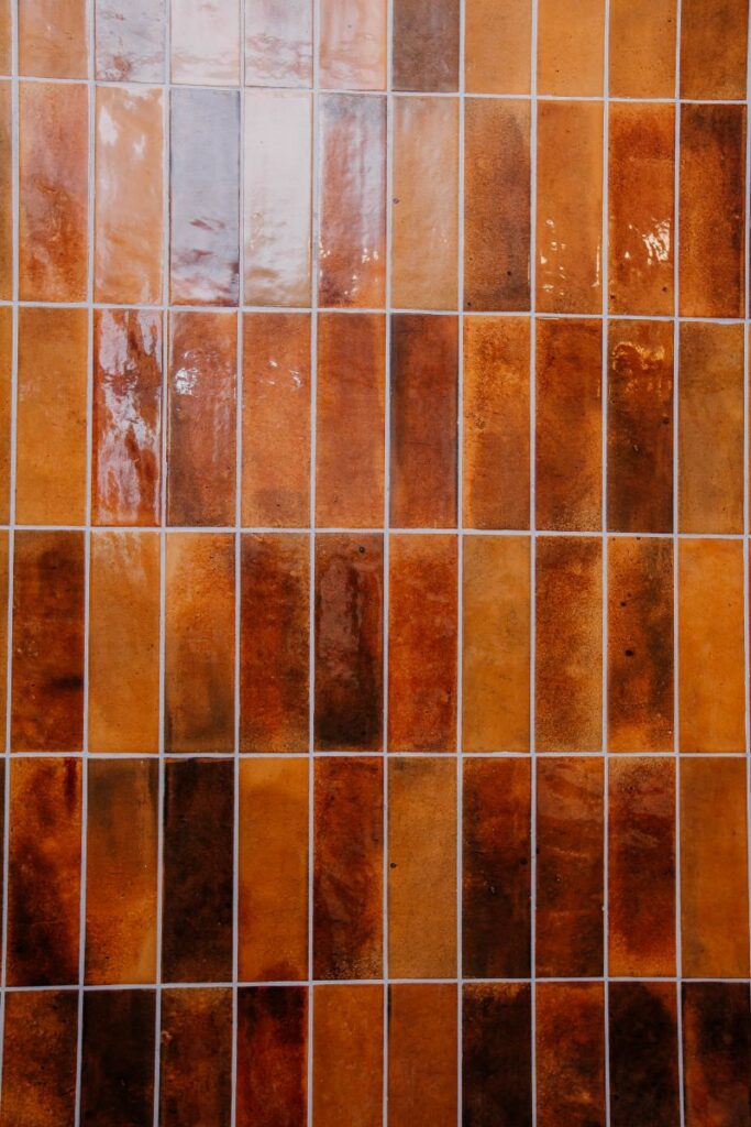 Close up of glossy rust toned vertical bathroom wall tile